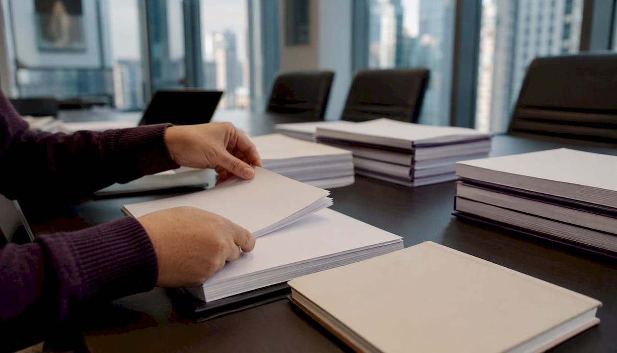 Hands organizing contract papers on desk