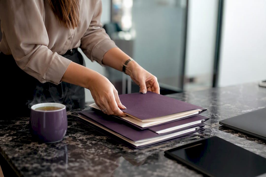 Hands arranging contract folders and tablet