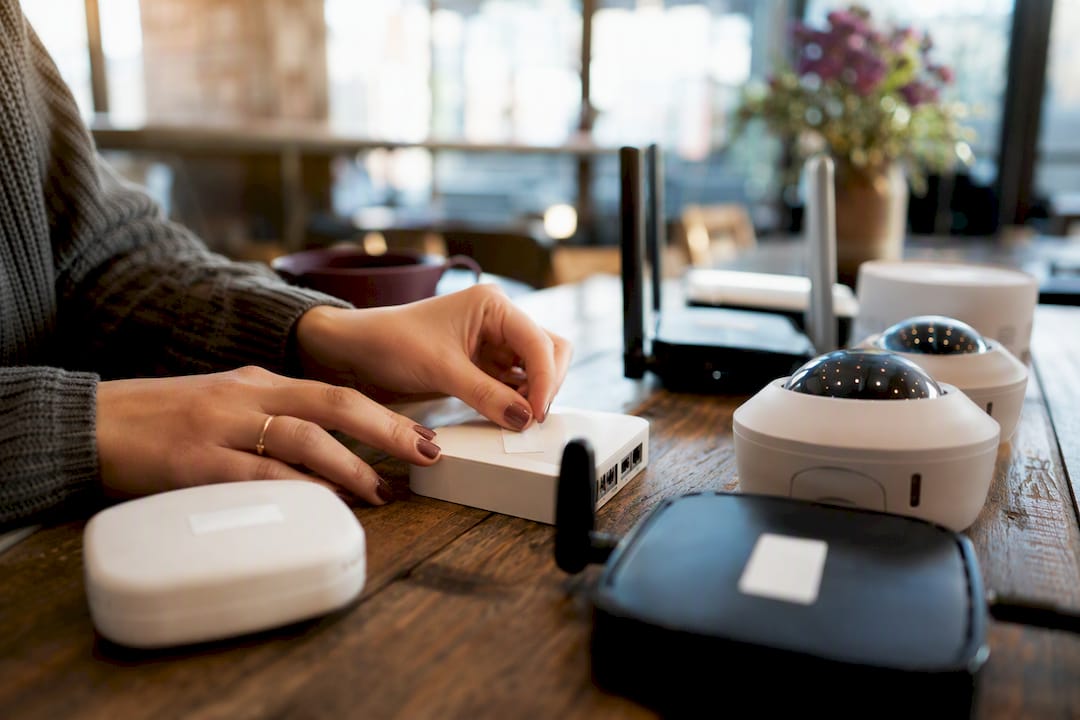 Hands tagging small hardware devices for compliance audit