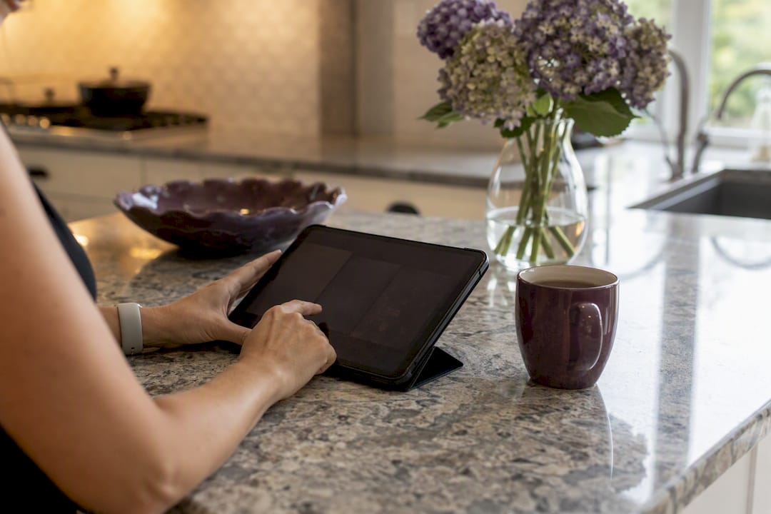 Hands tapping tablet with dark screen